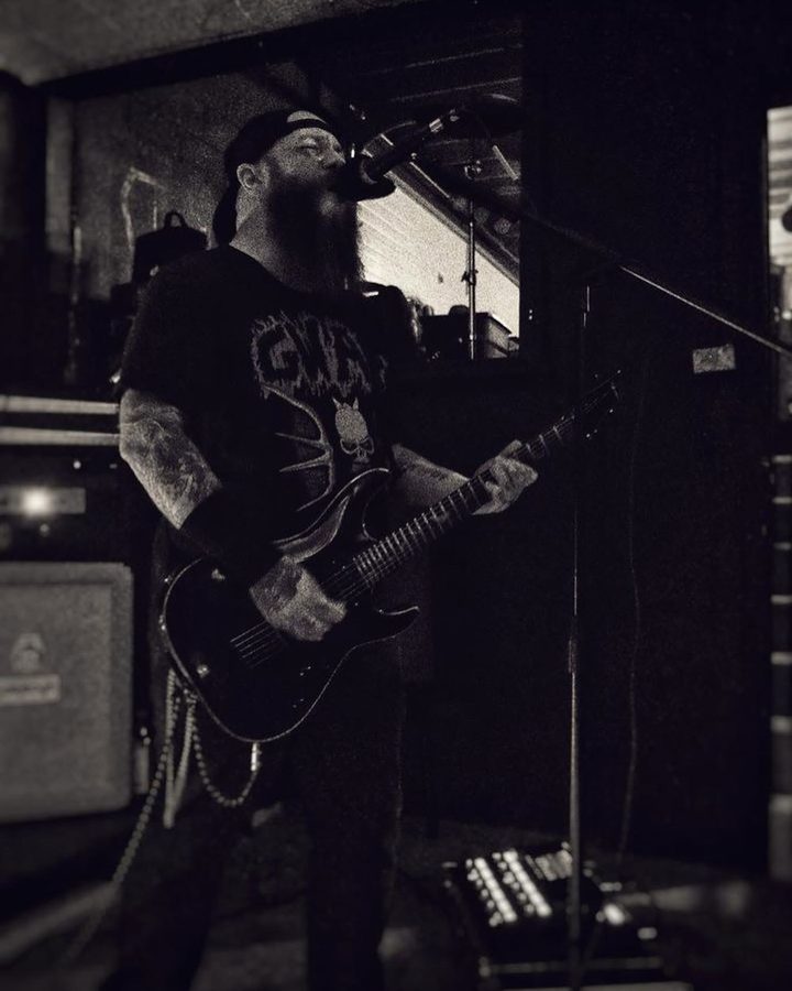Black and white photo of Nate Laff singing and playing guitar