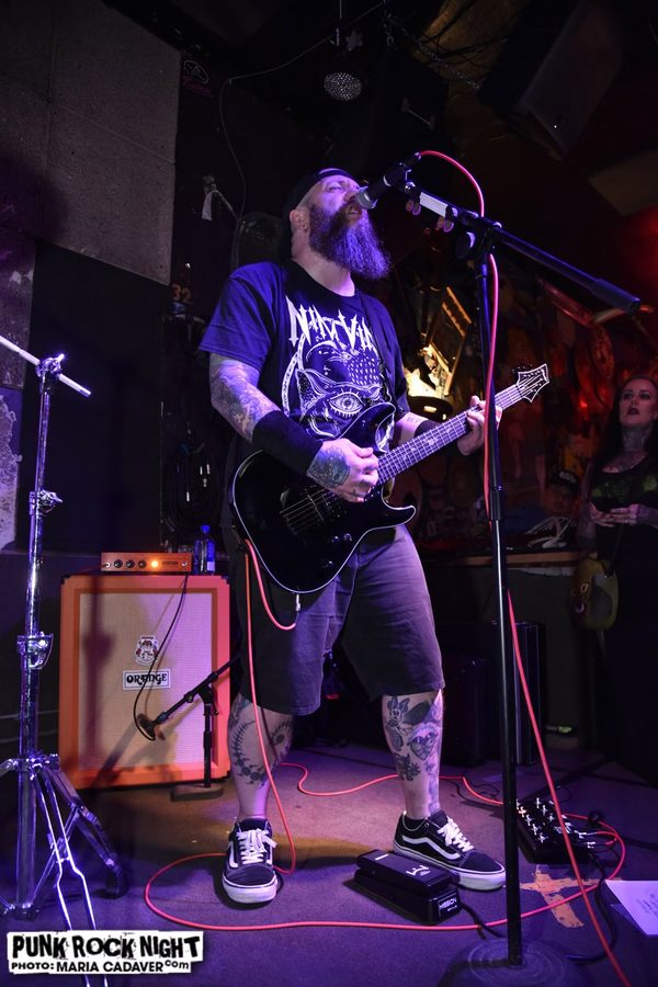 Nate Laff singing and playing guitar at the Melody Inn with an Orange amp behind him