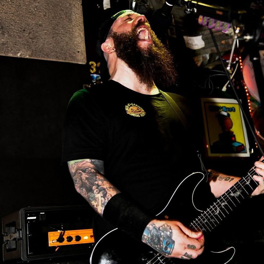 Nate Laff screaming toward the ceiling while playing guitar